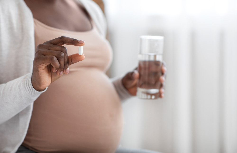 pregnant woman holding pill